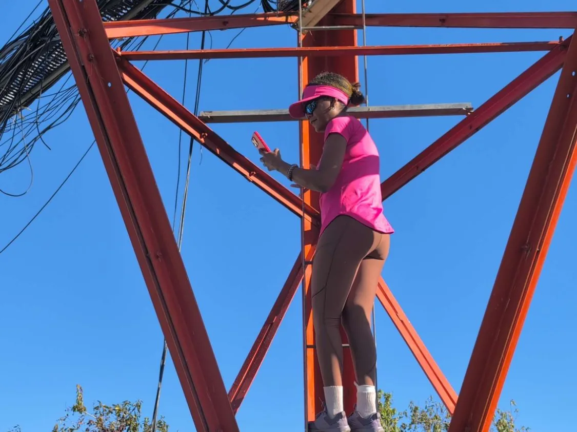 A Lifestyle Hiker on the red telecom tower at the summit of Catherine's Peak