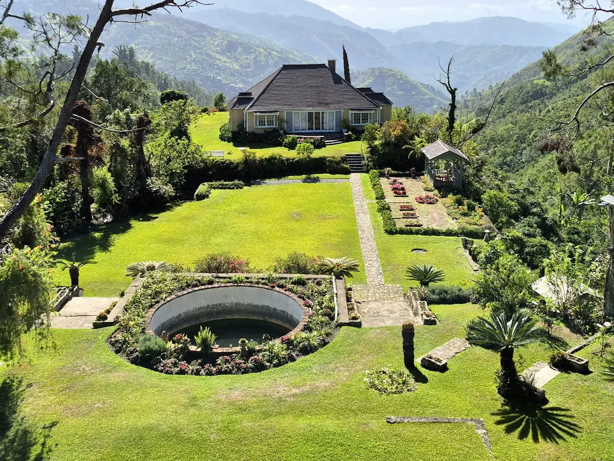 The great house and terraced gardens at Clifton Mount Coffee Estate, with the Blue Mountains behind