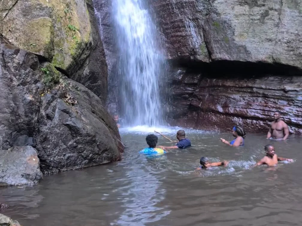Lifestyle Hikers swimming beneath Falling Edge Falls in St. Andrew, Jamaica